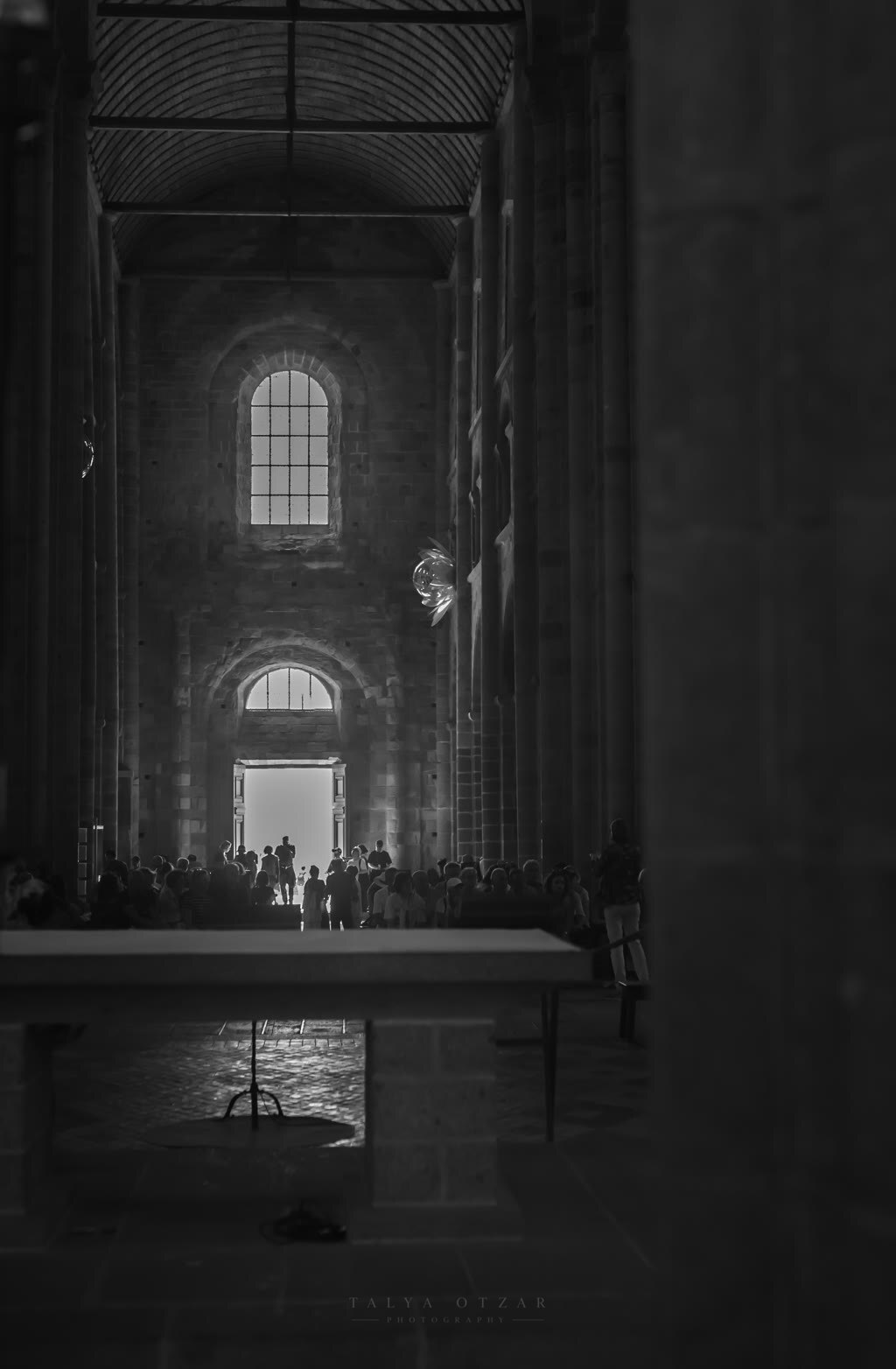 Visitors silhouetted against the bright doorway of the abbey church