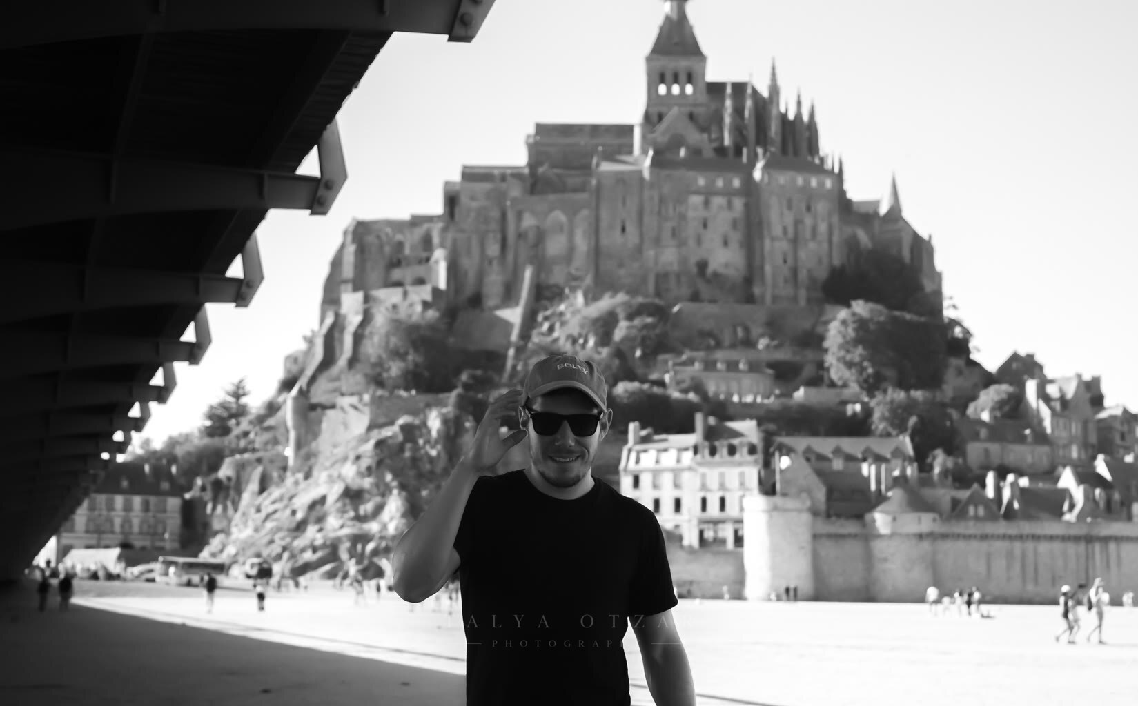 A man raising his cap in front of Mont-Saint-Michel