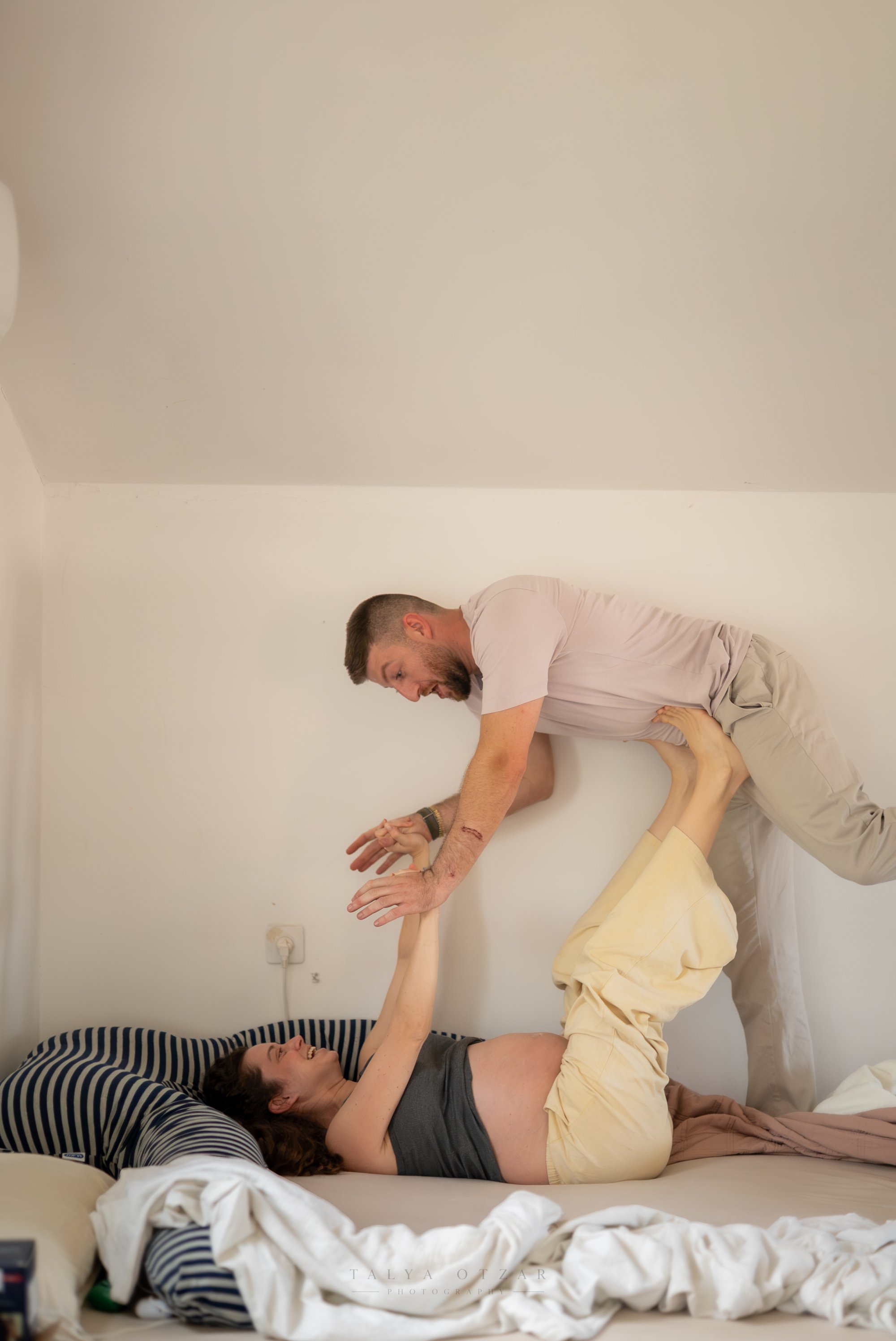 לוטם מתאזן בשובבות על כפות הרגליים של סיגי במיטה
