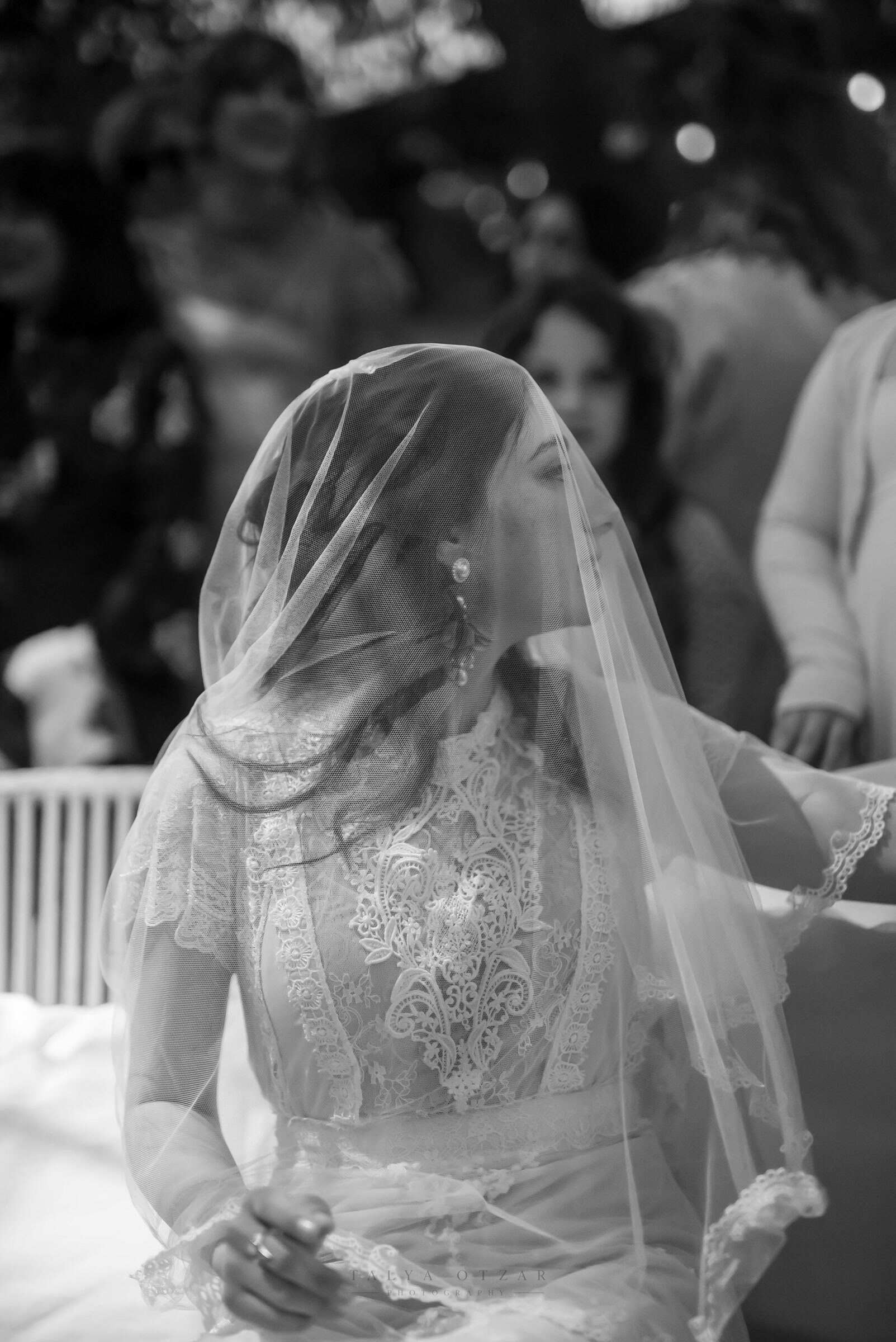 The bride beneath her lace veil in the moments before the ceremony