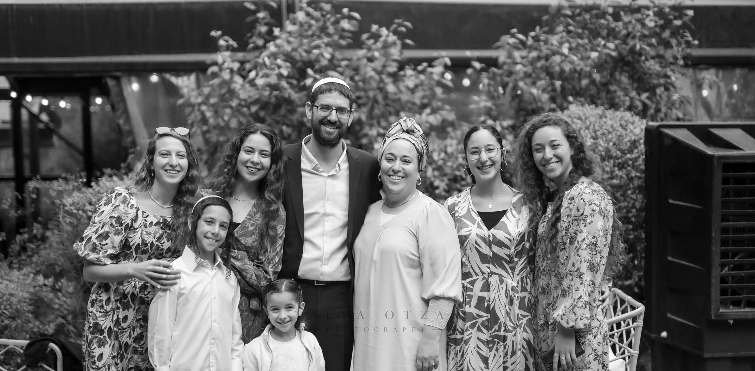A family group gathered for a portrait in the garden after the ceremony
