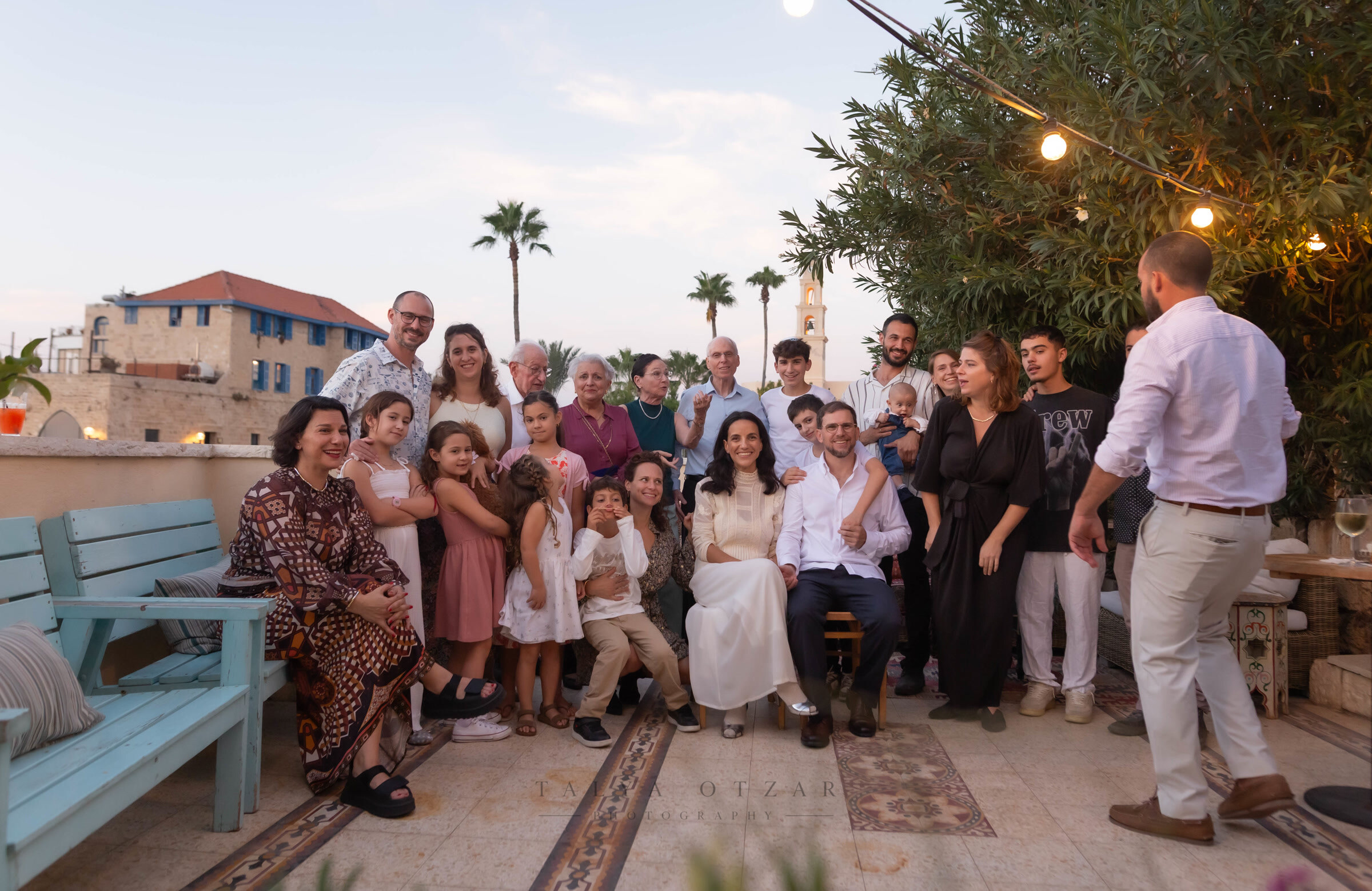 The whole party gathered for a group portrait on the Jaffa rooftop at dusk