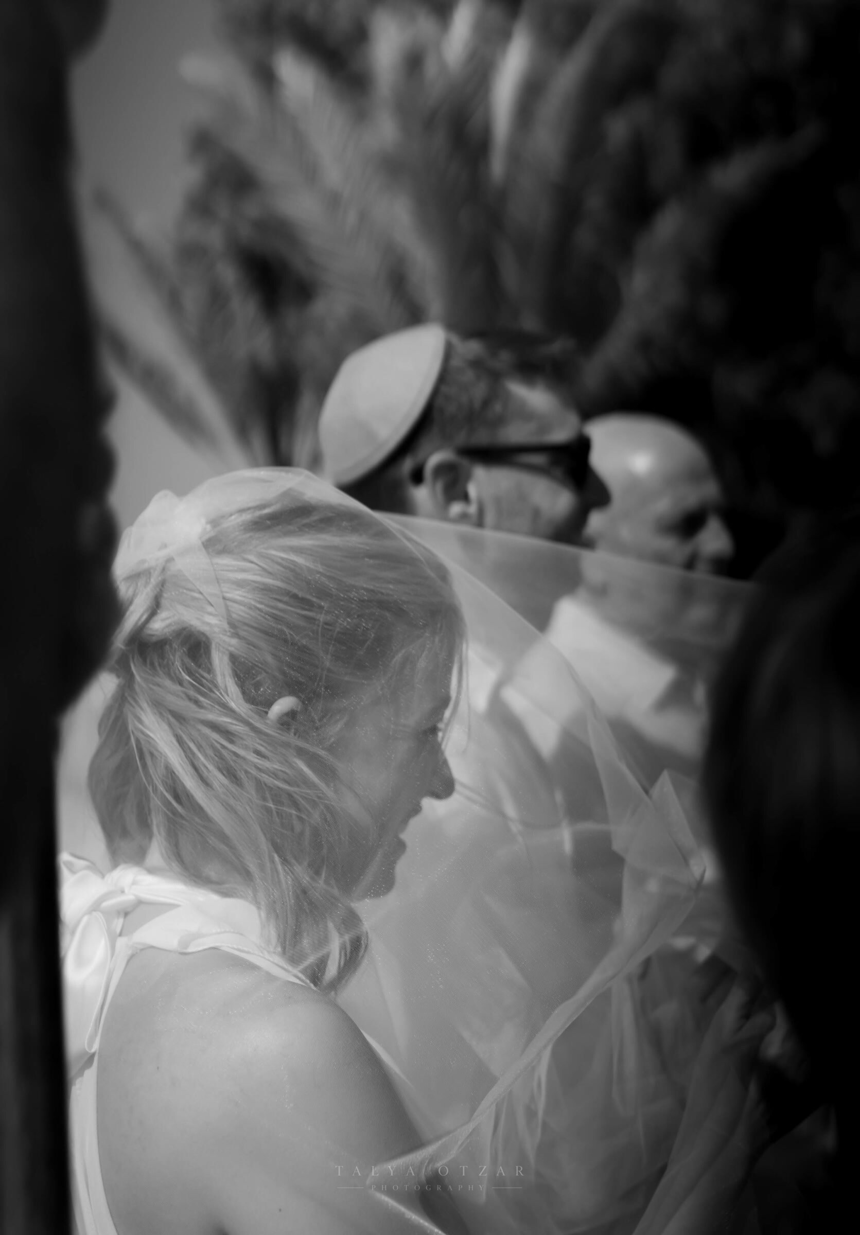 Bride and groom together beneath the veil in the moments before the ceremony