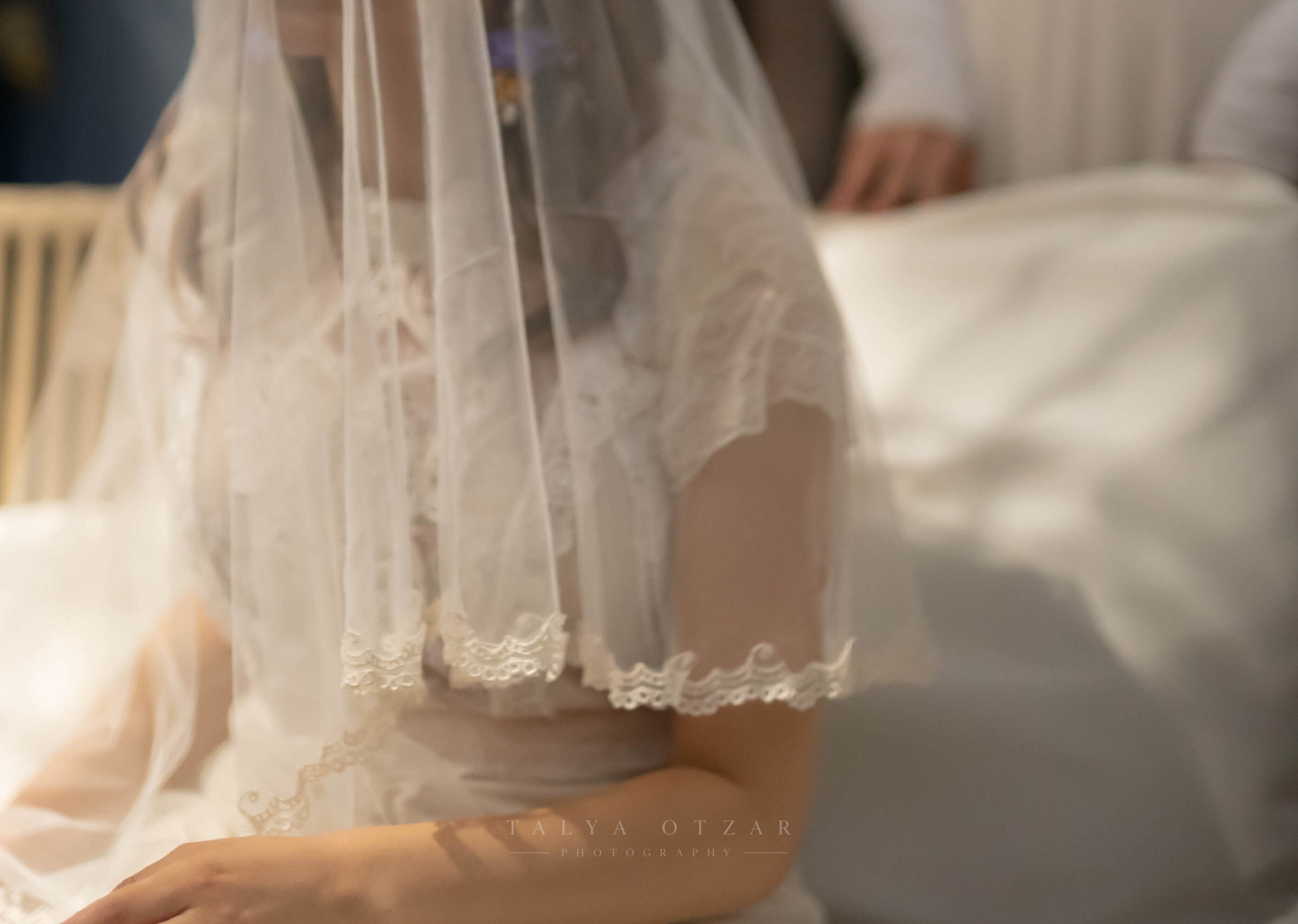 A close detail of the bride's lace veil resting over her shoulder