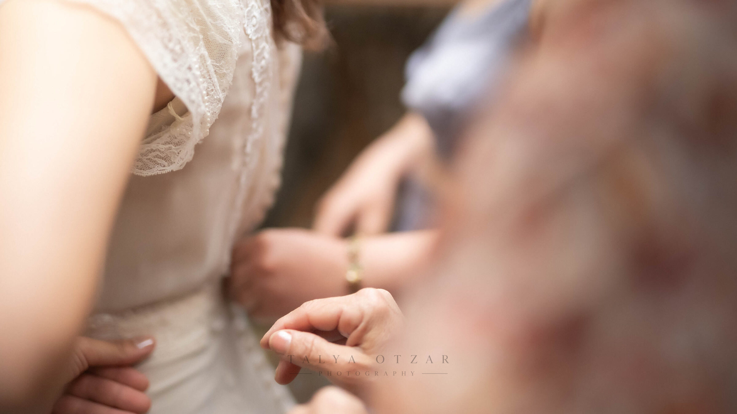 The bride's hand with the ring newly on her finger, lace sleeve just visible