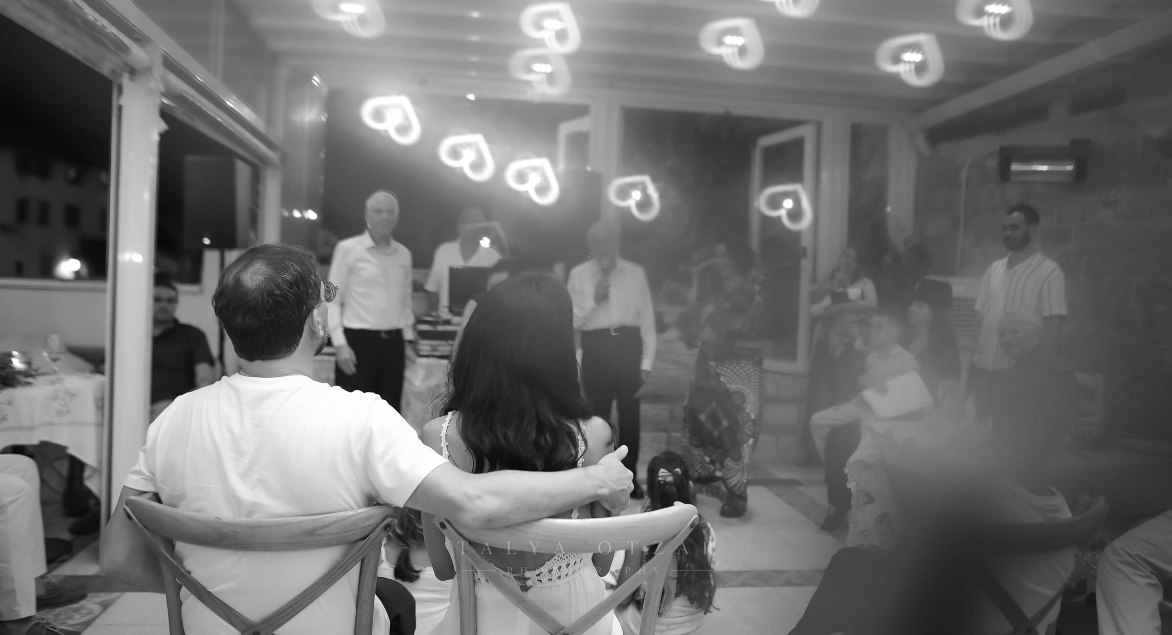 Guests watching the evening's performance, heart-shaped lights hanging above them