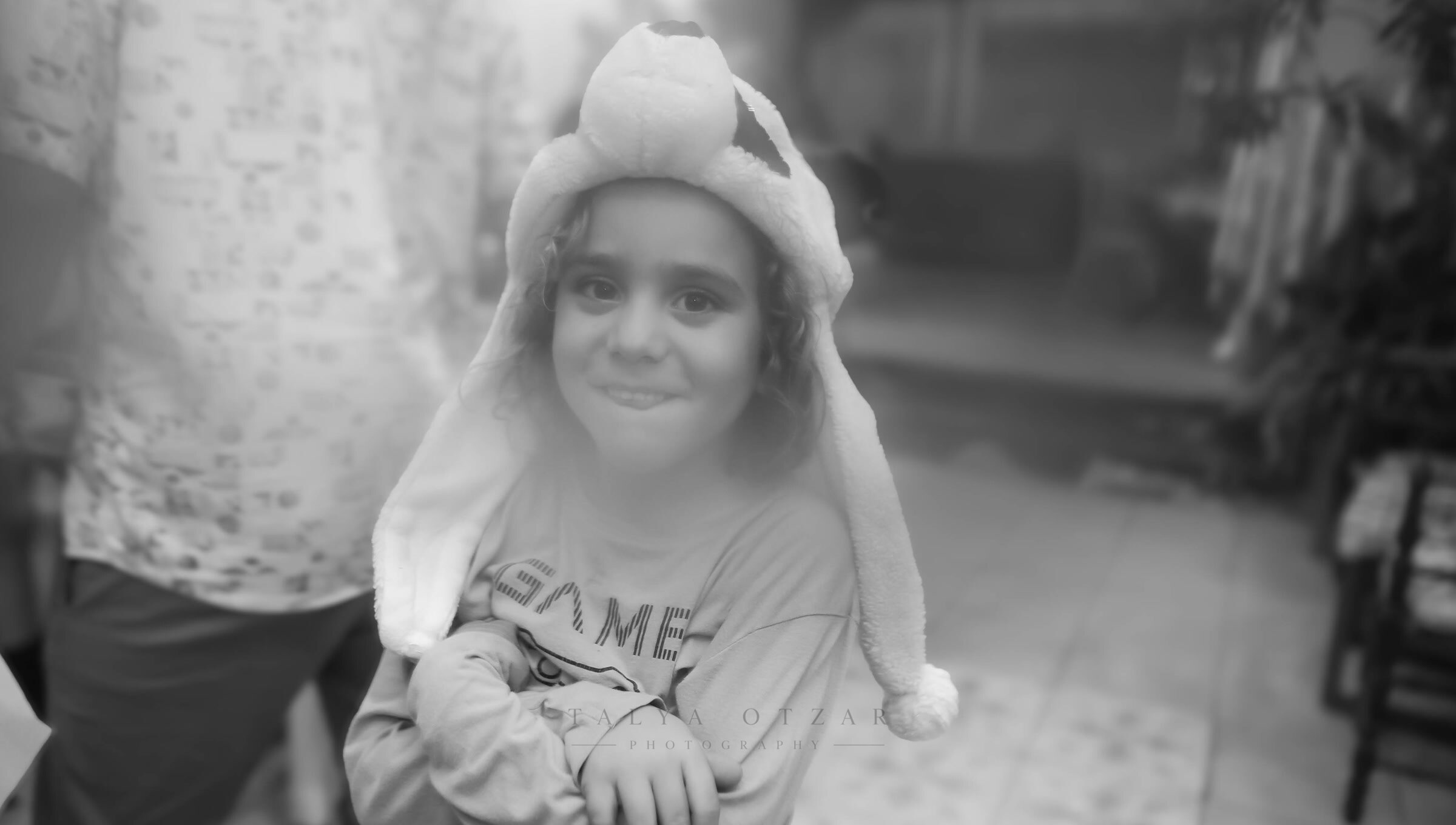 A young guest in a soft animal hat smiling at the camera