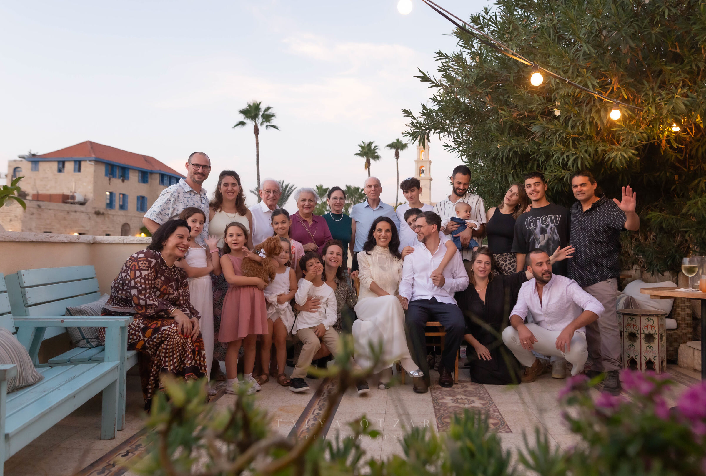 Everyone gathered on the Jaffa rooftop for the group portrait, festoon lights and the bell tower behind