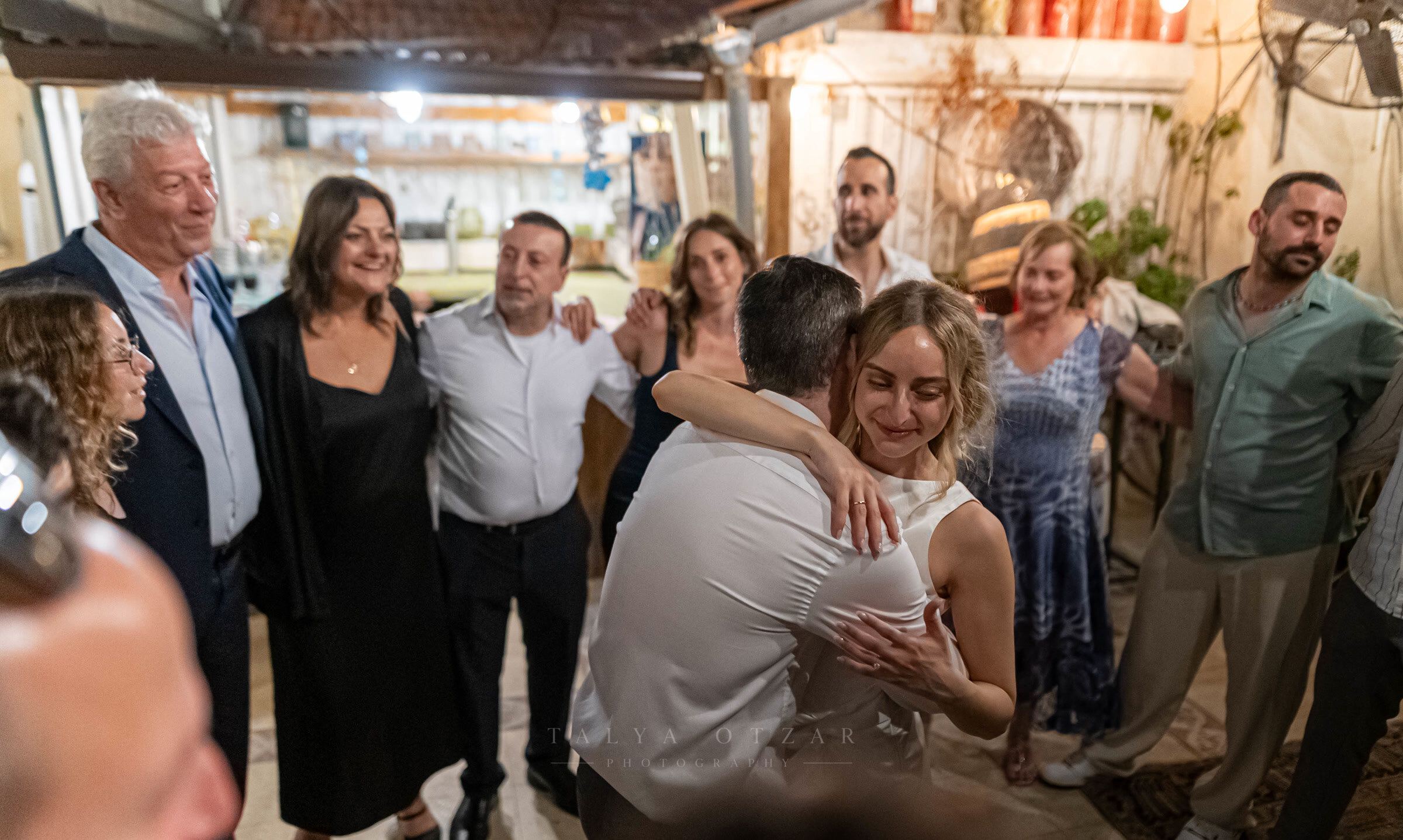 The couple's first dance in the courtyard, parents and guests watching from the edges