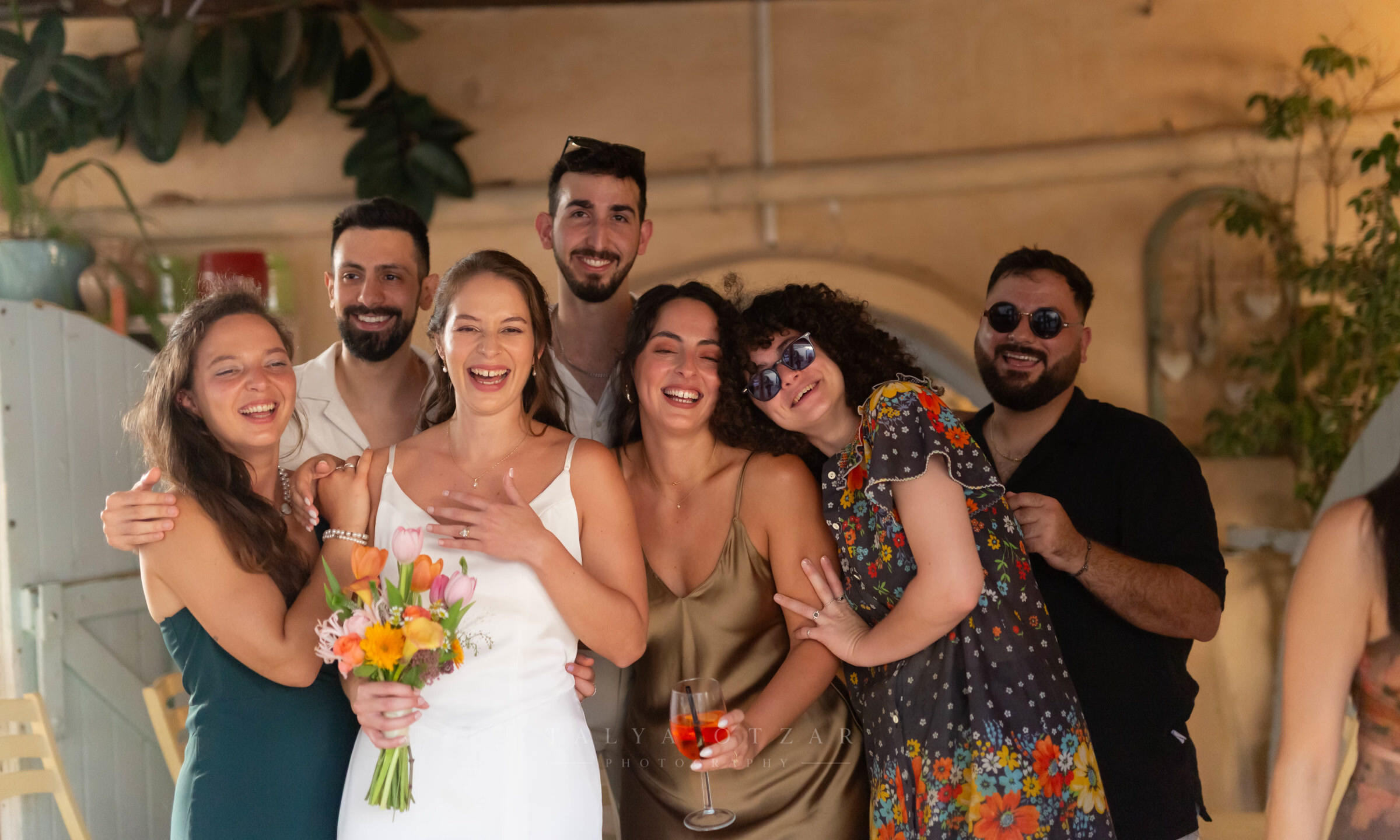 The bride and her friends laughing together, tulips in her hands
