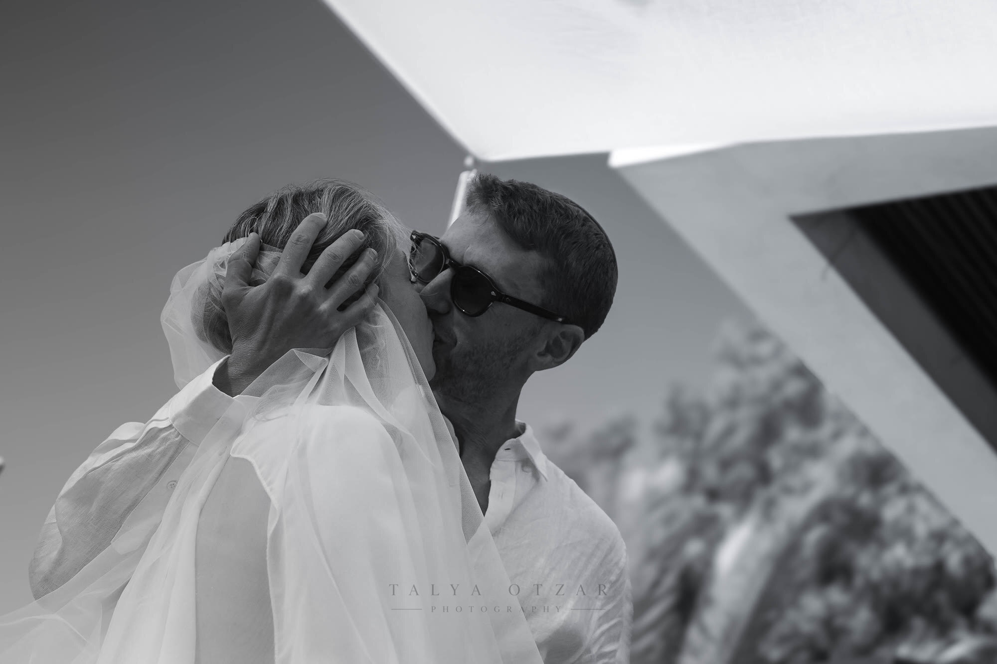 Documentary wedding photography of a couple sharing a kiss