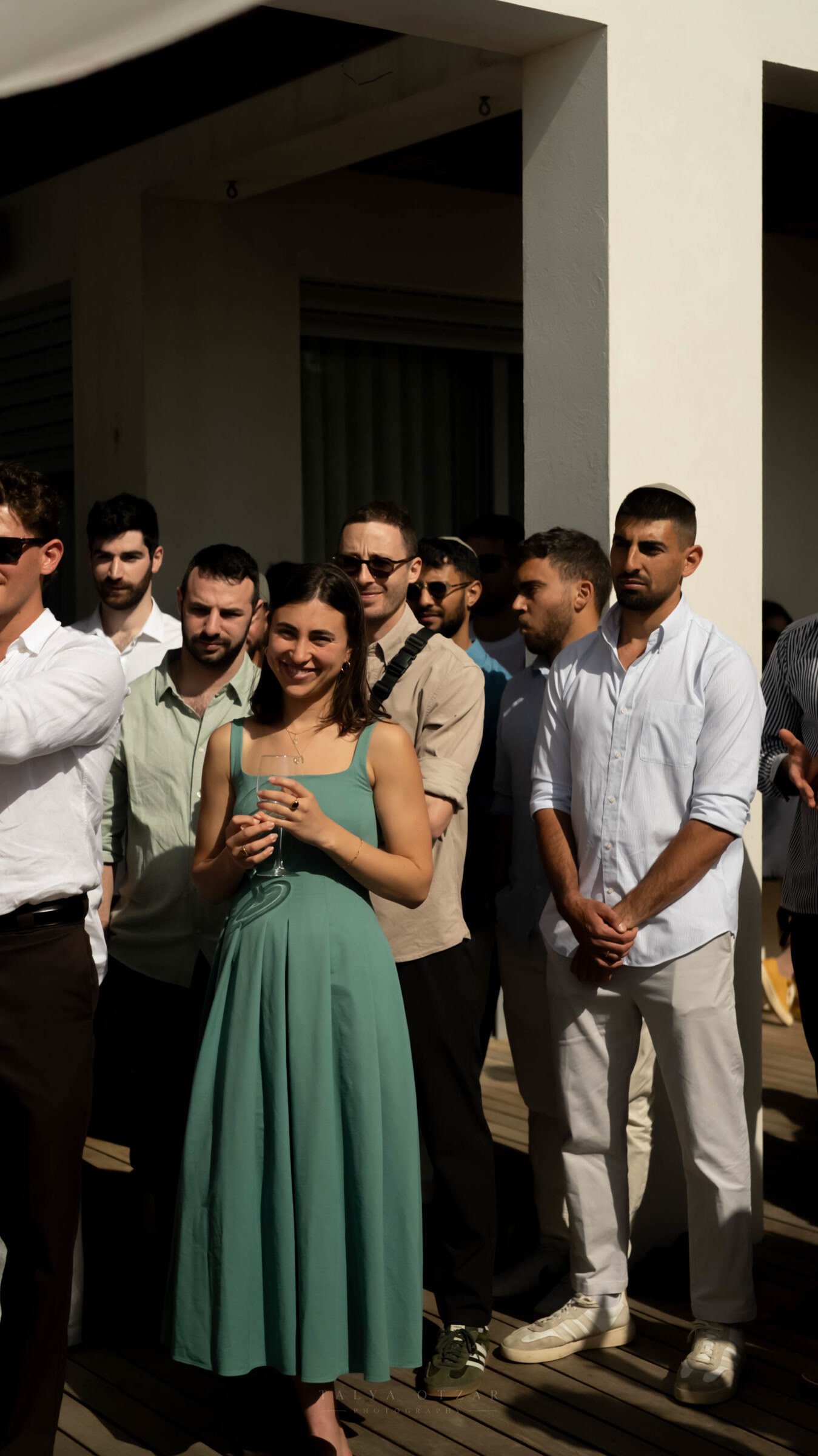 Guests standing in the sun on the deck, waiting for the ceremony to begin