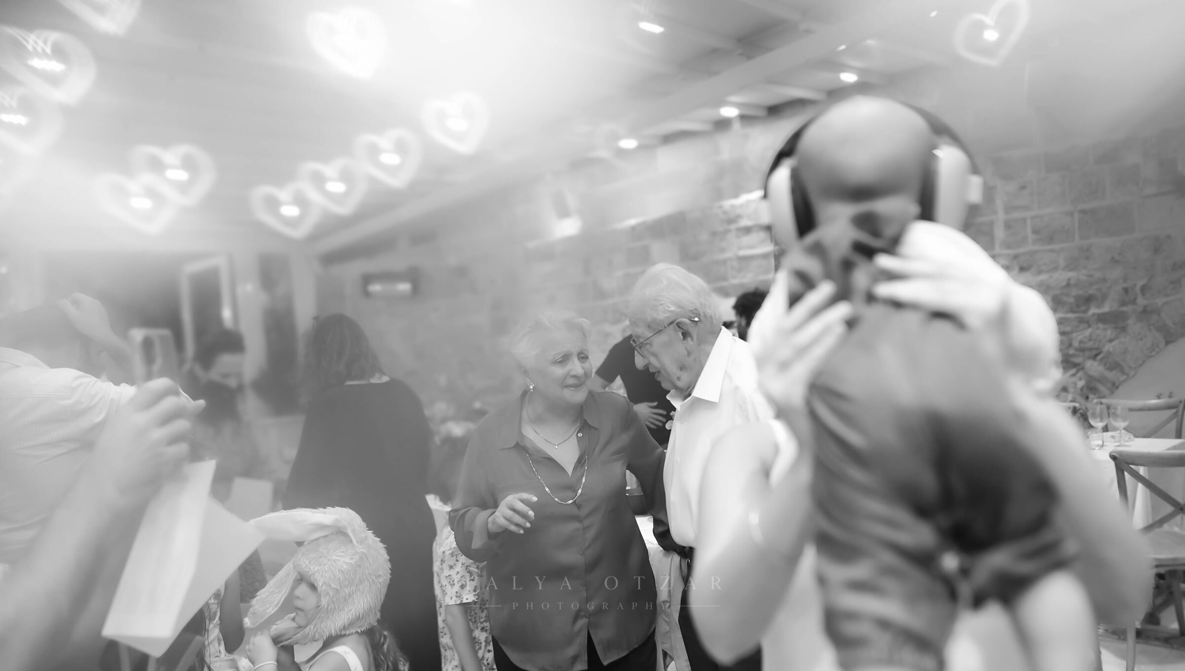 An older couple dancing among the guests under the hanging lights