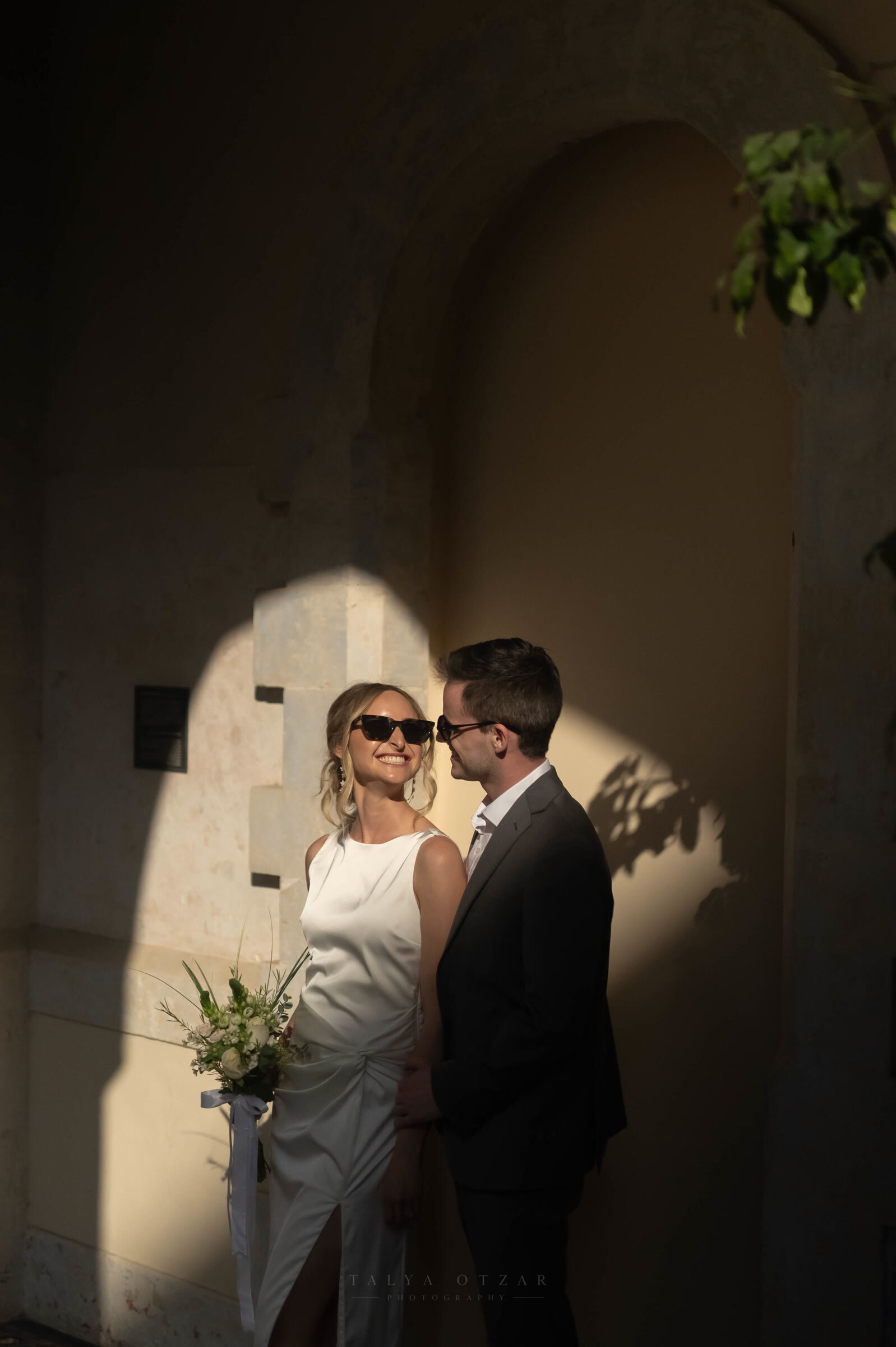 The couple facing each other in the last of the sunlight on the old stone wall