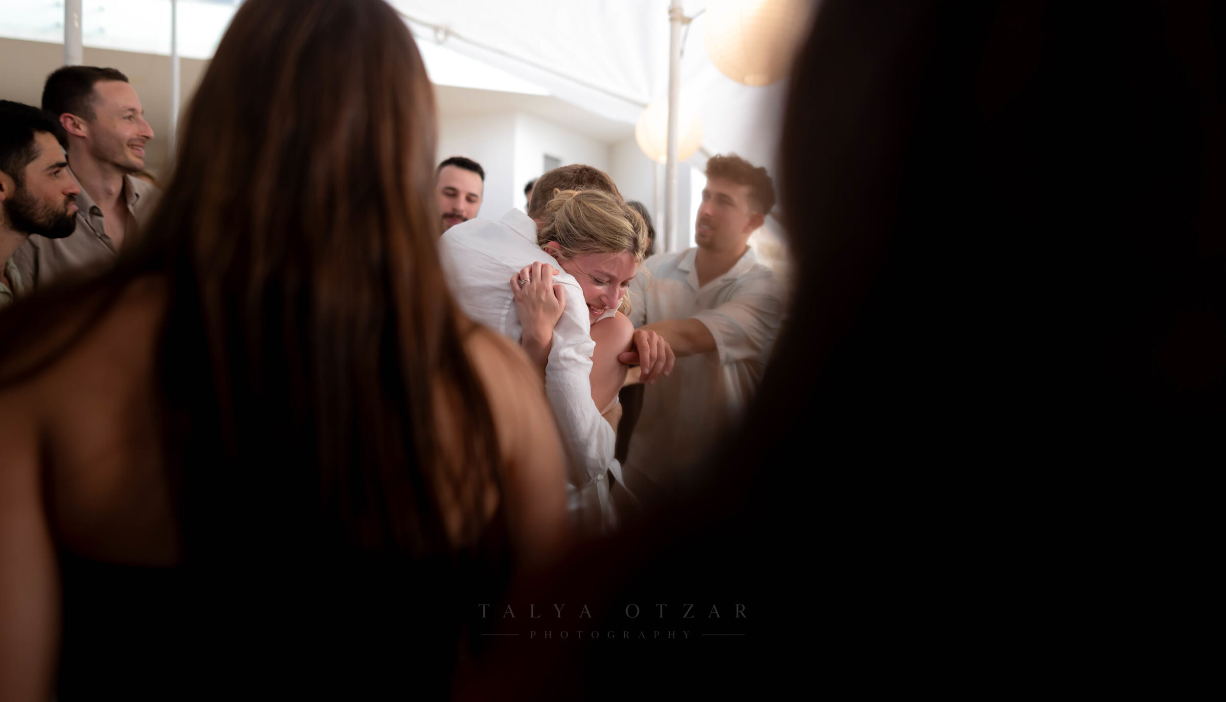 The bride surrounded by friends in a moment of laughter