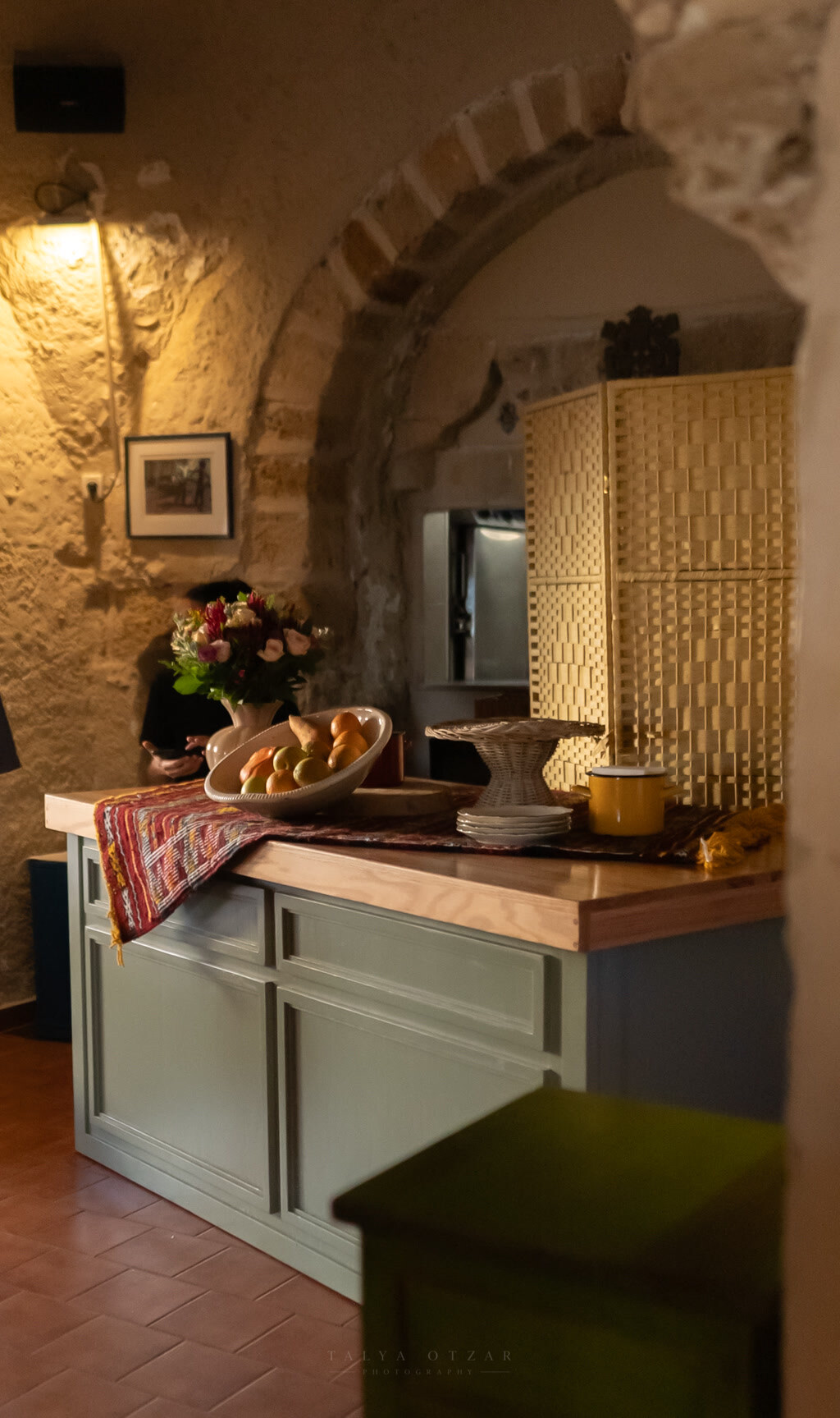 The venue's stone-arched interior in lamplight, flowers and fruit set out on the sideboard