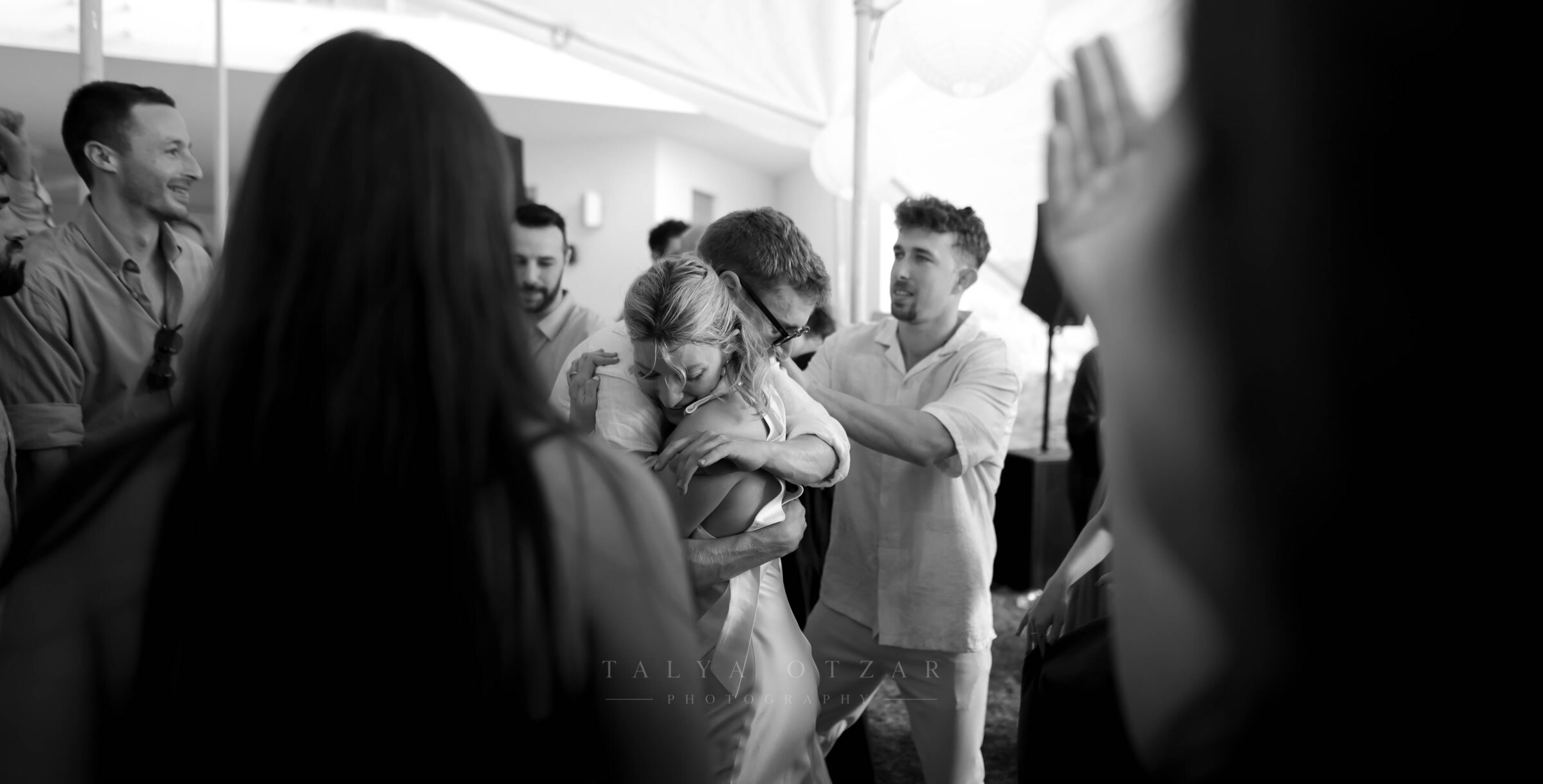 The bride held by her family in the middle of the crowd