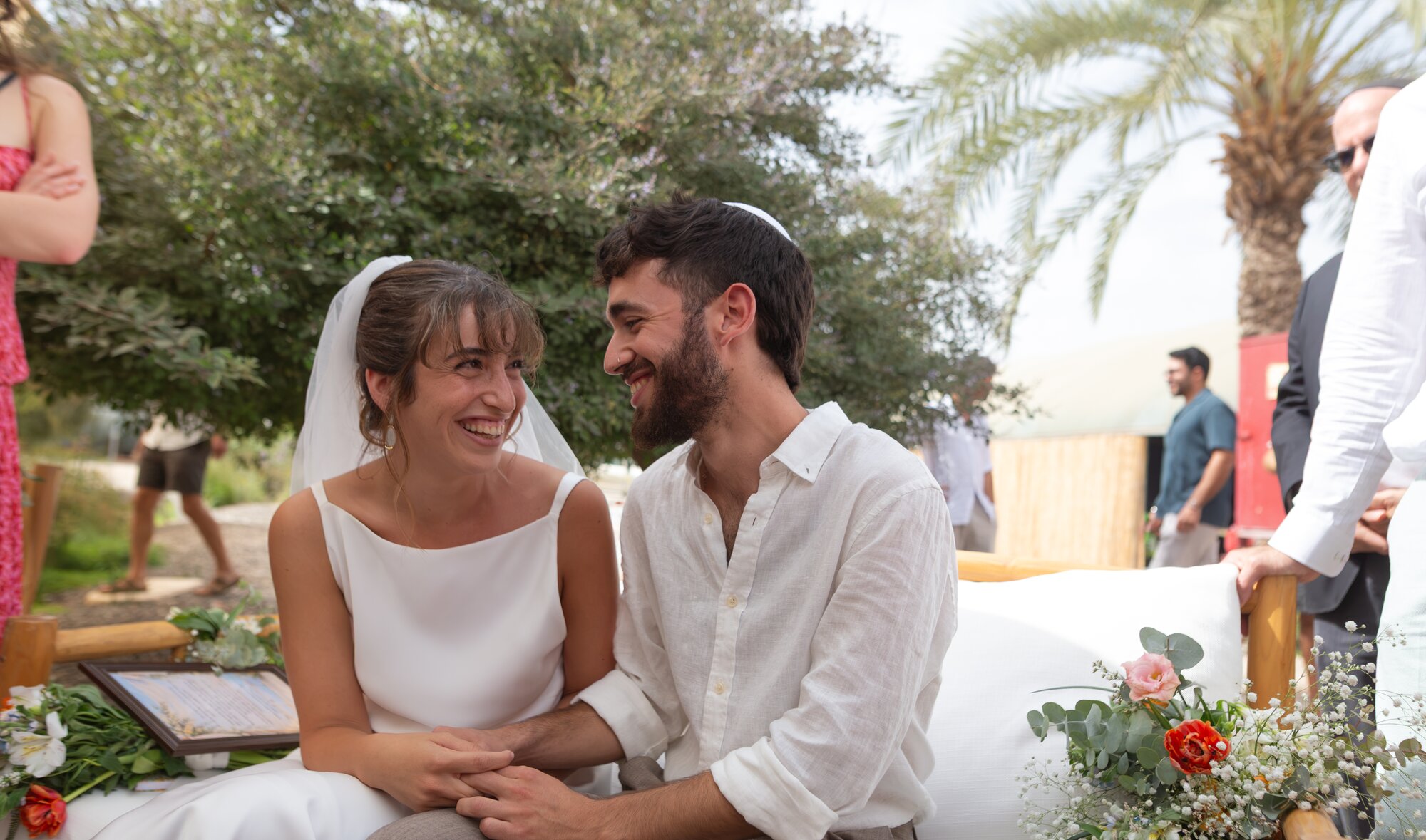 The bride and groom sitting close together and laughing before the ceremony