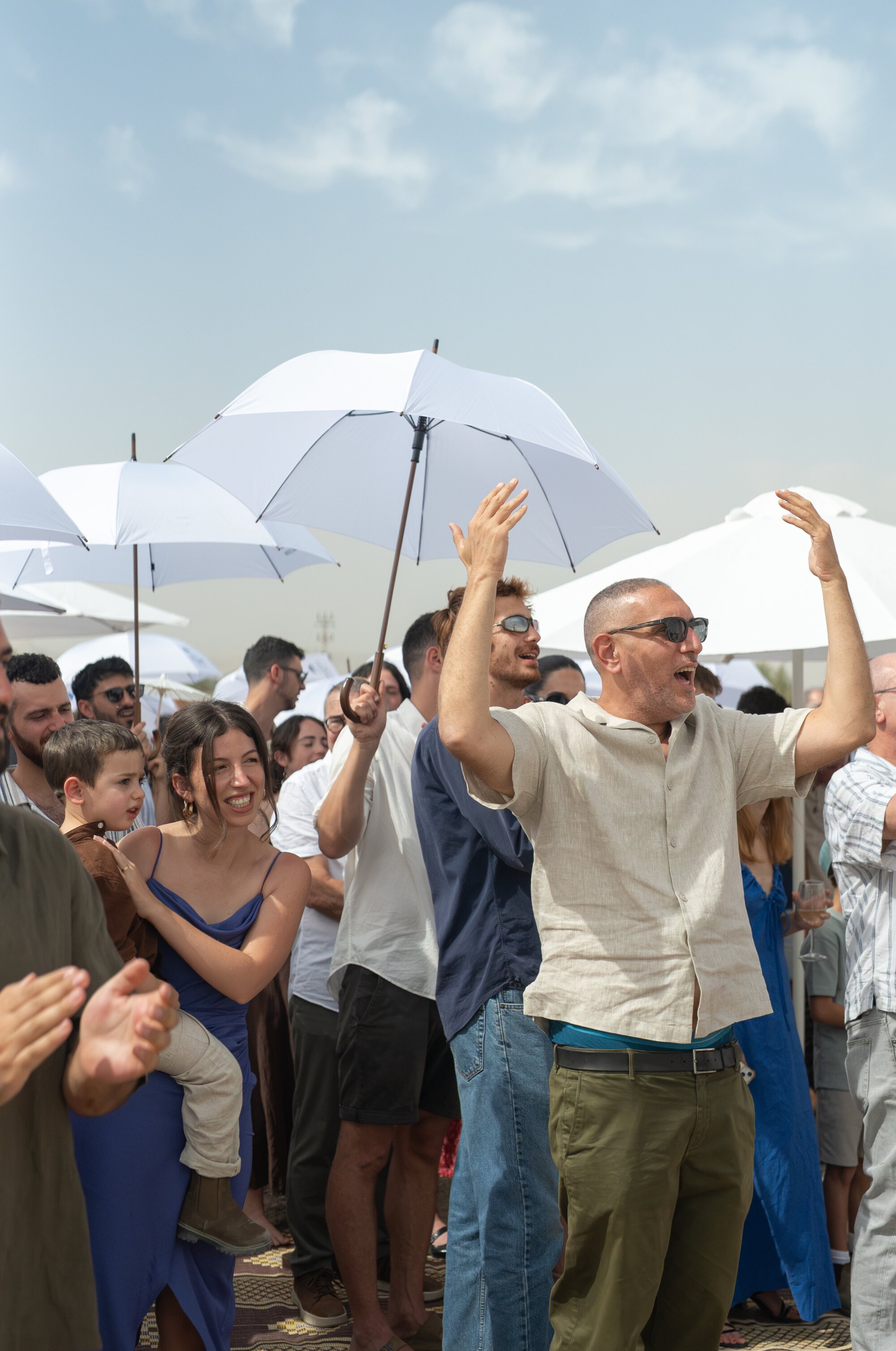 Guests raising their arms and cheering during the ceremony