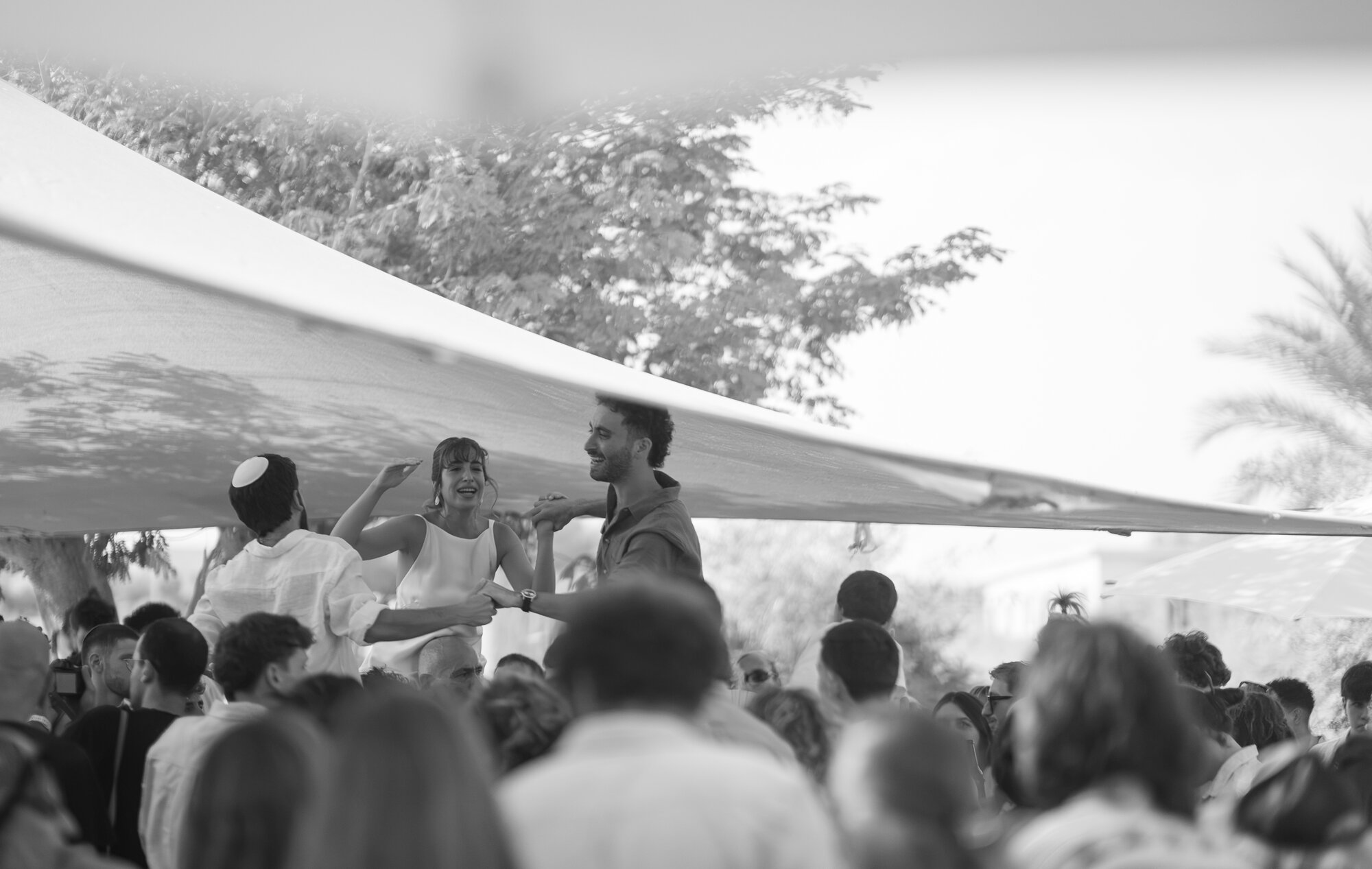 Guests dancing under the canopy, black and white